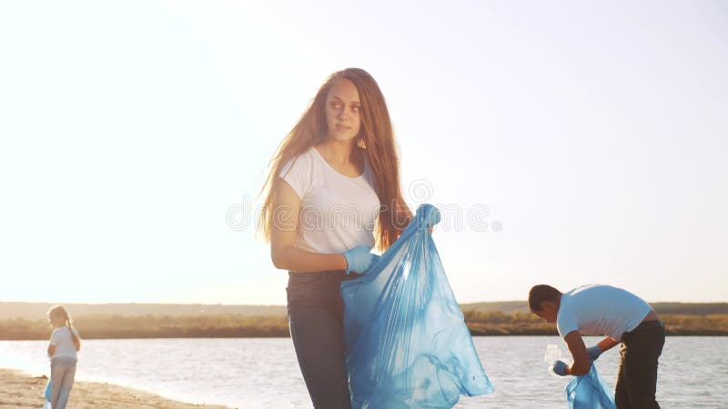Les gens de collecte volontaire de déchets un travail d'équipe. La famille heureuse de groupe rassemble les bouteilles en plastiqu banque de vidéos
