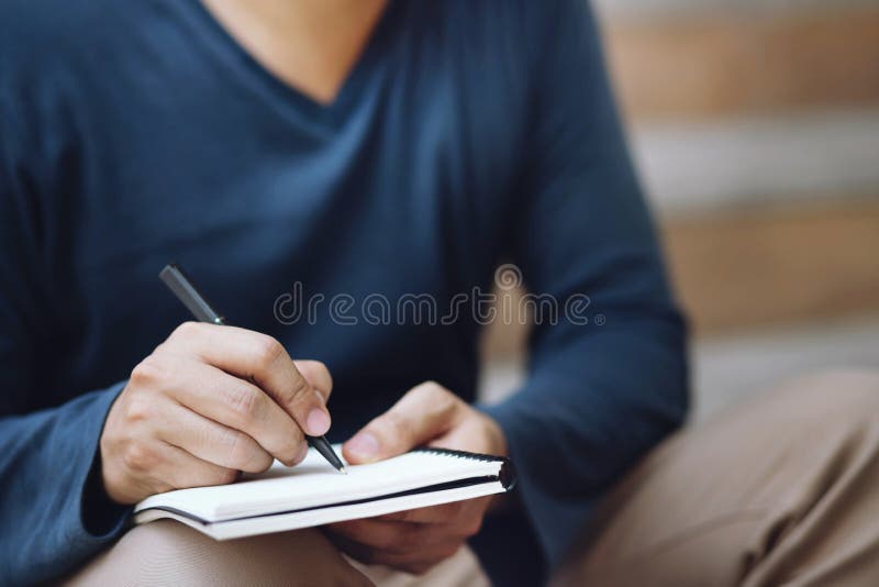 Les gens de près sont assis sur un escalier utilisation de l'écriture manuscrite Enregistrer la note de conférence dans le livre image stock Les gens de près sont assis sur un escalier utilisation de l'écriture manuscrite Enregistrer la note de conférence dans le livre image stock