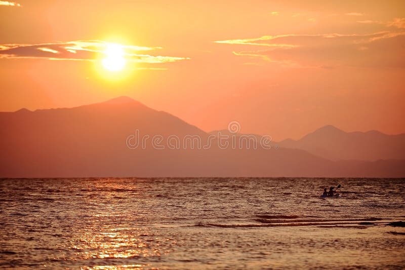 Les gens kayaking sur le lac Shkodra au coucher du soleil photo libre de droits Les gens kayaking sur le lac Shkodra au coucher du soleil photo libre de droits