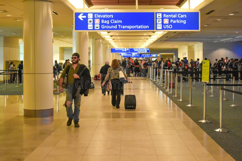 Les gens marchant dans l'enregistrement et étiquetant le secteur chez Orlando International Airport 1 photo stock Les gens marchant dans l'enregistrement et étiquetant le secteur chez Orlando International Airport 1 photo stock