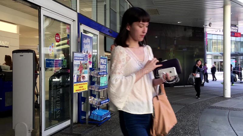 Les gens marchant par les portes au drugstore de Londres