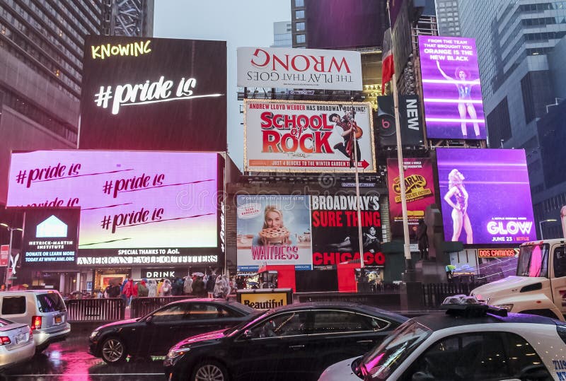 New York états-unis le 19 juin 2017 : Les gens marchant à l'entraînement de parasols et de véhicules par Times Square lors d'un après-midi pluvieux entouré de lumières colorées des signes de publicité