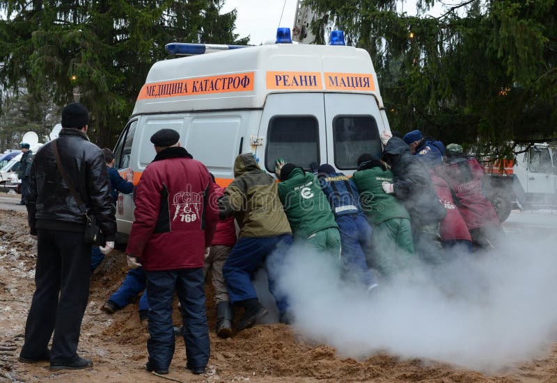 Les gens poussent une ambulance coincée de ressuscitation de voiture photos libres de droits Les gens poussent une ambulance coincée de ressuscitation de voiture photos libres de droits