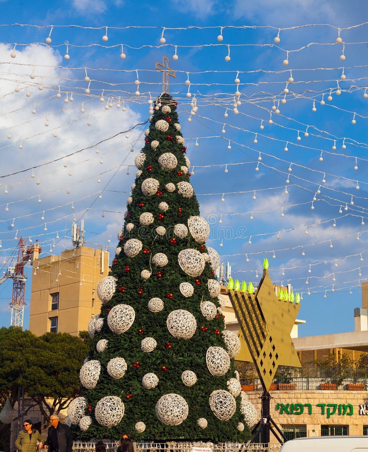 Les gens prennent des photos devant le sapin de Noël image libre de droits Les gens prennent des photos devant le sapin de Noël image libre de droits
