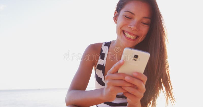 Les gens qui utilisent la femme de téléphonie mobile utilisant le sourire extérieur smartphone