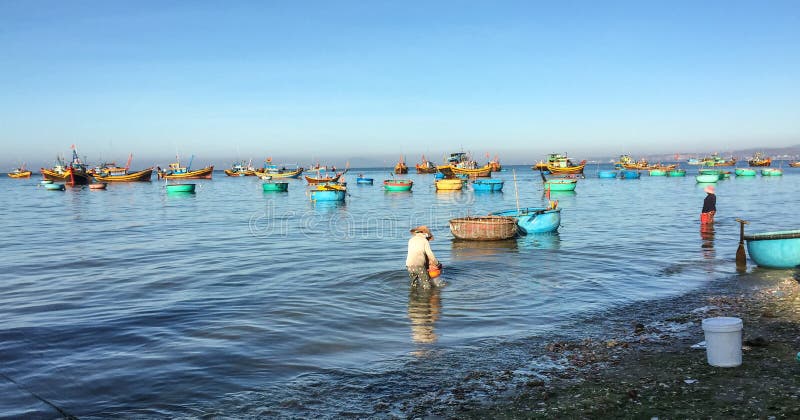 Les gens travaillant à la plage avec beaucoup de bateaux de pêche en Phan ont sonné, le Vietnam photo libre de droits Les gens travaillant à la plage avec beaucoup de bateaux de pêche en Phan ont sonné, le Vietnam photo libre de droits