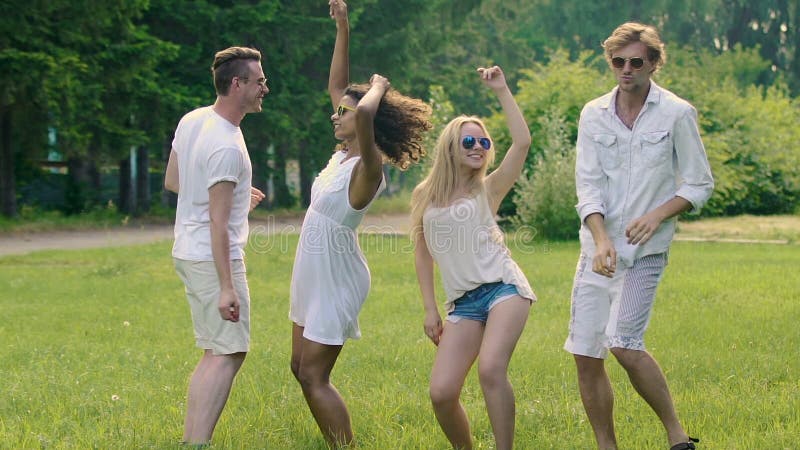 Les hommes beaux heureux dansant avec de belles femmes flirty à l'été extérieur font la fête banque de vidéos