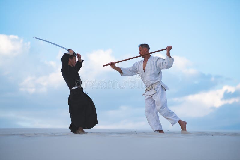 Les hommes concentrés, dans des vêtements japonais, pratiquent des arts martiaux image libre de droits Les hommes concentrés, dans des vêtements japonais, pratiquent des arts martiaux image libre de droits