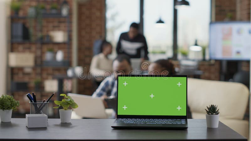 Les hommes d'affaires ayant un fond d'écran vert sur ordinateur portable avec bureau. affichage de l'ordinateur avec clé chroma vierge modèle de maquette isolée et copier la technologie de l'espace sur le périphérique. tir de trépied.