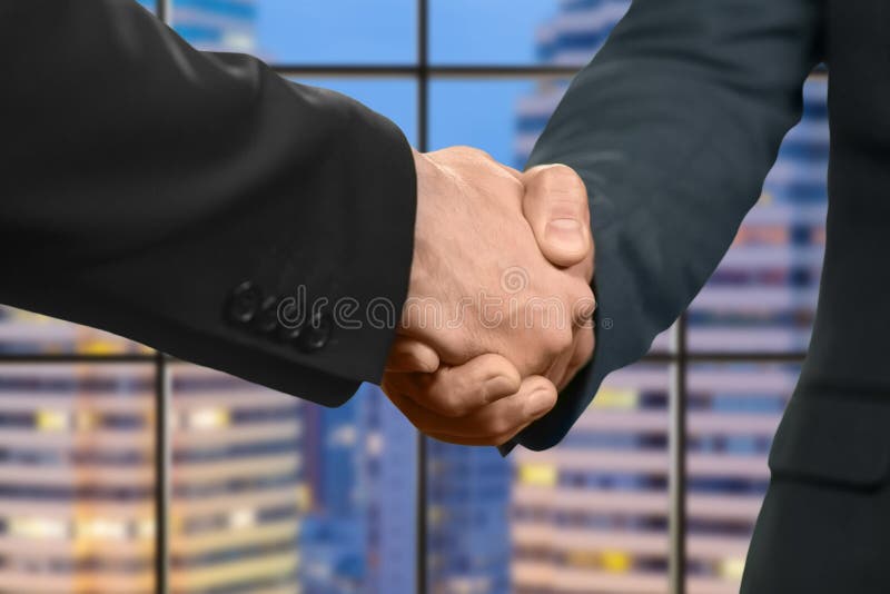 Adult caucasian businessmen shake hands. Handshake in evening megalopolis. It's nice to meet you. Partner for election campaign. Adult caucasian businessmen shake hands. Handshake in evening megalopolis. It's nice to meet you. Partner for election campaign.