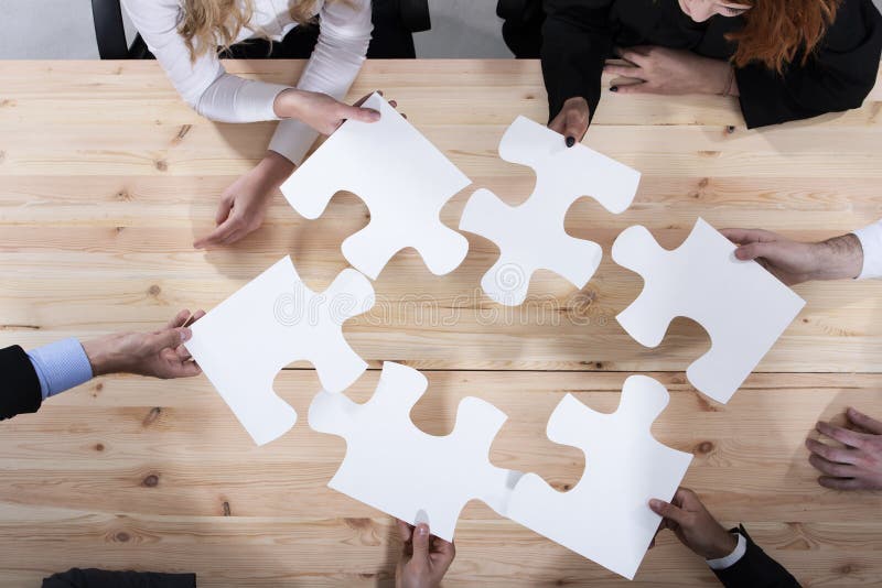 Les hommes d'affaires travaillent ensemble pour établir un puzzle Concept de travail d'équipe, d'association, d'intégration et de photos stock