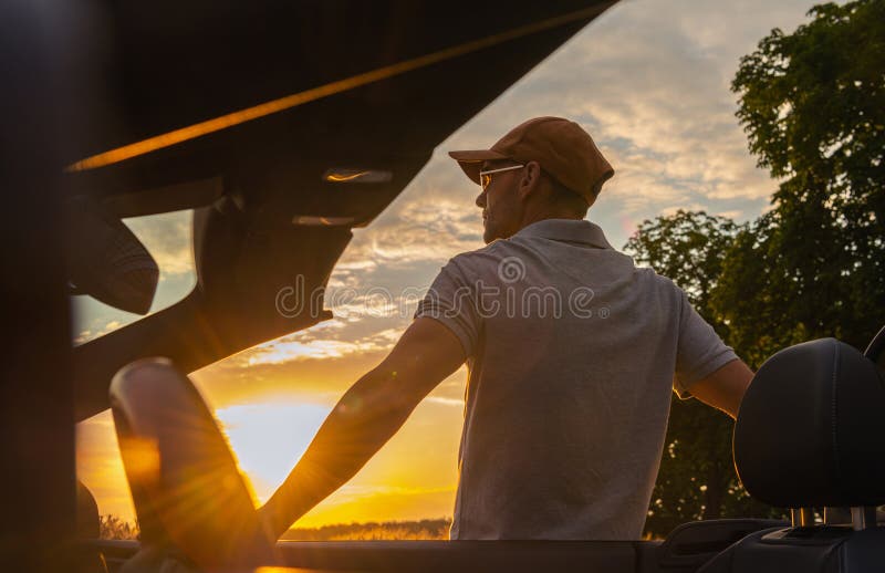 Les hommes s'arrêtent au bord de la route pour profiter du coucher de soleil panoramique images stock