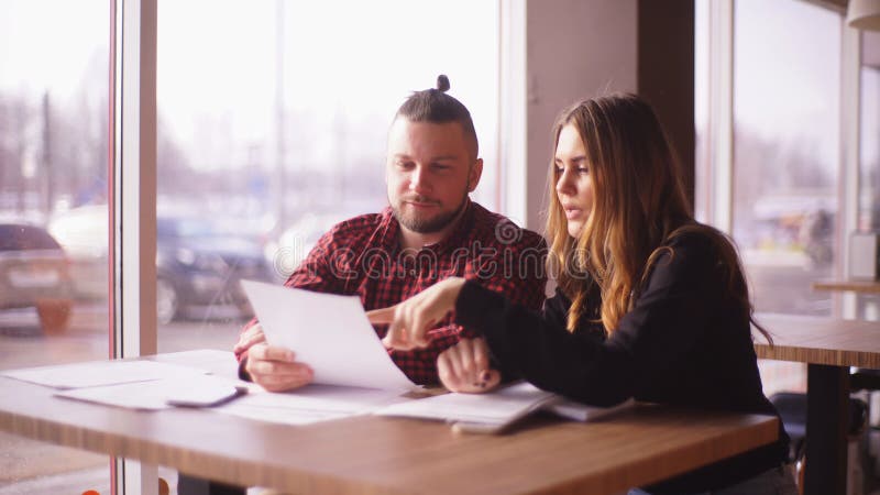 Les indépendants un homme et une femme discutent une affaire dans le café