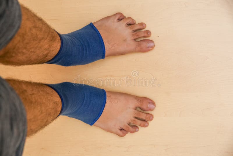 Les jambes des hommes après la parésie des extrémités inférieures avec un bandage médical bleu spécial Vue de ci-avant photos libres de droits Les jambes des hommes après la parésie des extrémités inférieures avec un bandage médical bleu spécial Vue de ci-avant photos libres de droits