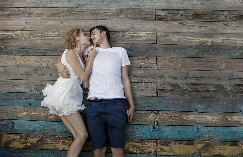 Les jeunes couples affectueux appréciant la nature, un jeune homme et la fille dans une robe blanche se trouvent ensemble photo libre de droits Les jeunes couples affectueux appréciant la nature, un jeune homme et la fille dans une robe blanche se trouvent ensemble photo libre de droits