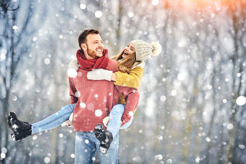 Les jeunes couples heureux en hiver garent rire et avoir l'amusement Famille à l'extérieur images stock