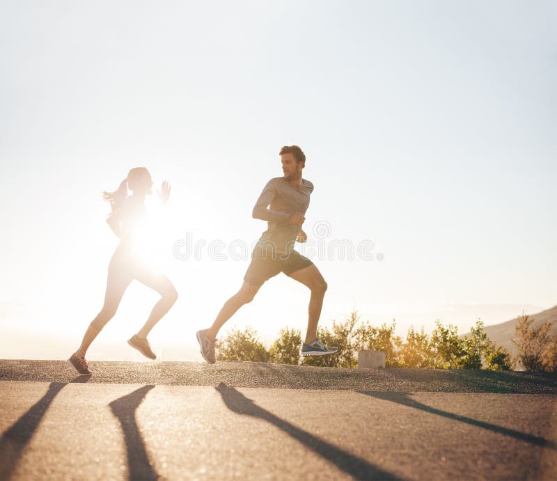 Les jeunes courant sur la route de campagne photos stock Les jeunes courant sur la route de campagne photos stock