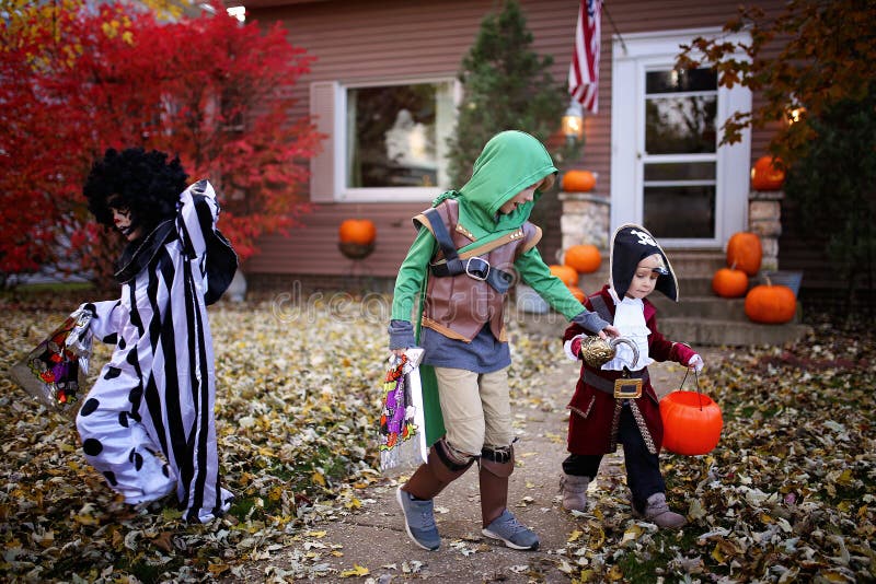 Les jeunes enfants habillés en costumes en trompe ou en traitement à l'Halloween en Amérique photographie stock Les jeunes enfants habillés en costumes en trompe ou en traitement à l'Halloween en Amérique photographie stock
