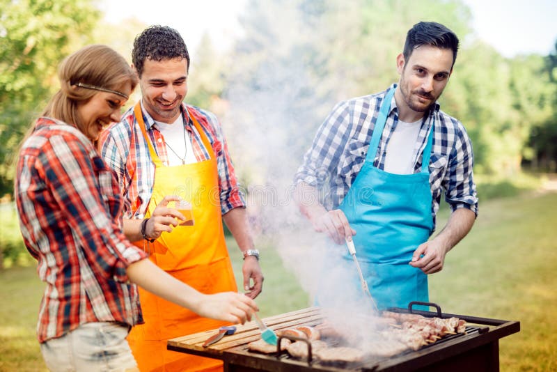 Les jeunes grillant dehors photos stock Les jeunes grillant dehors photos stock