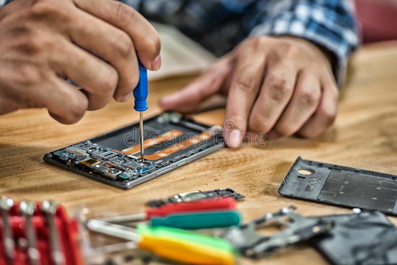 les jeunes hommes réparent un téléphone portable photos libres de droits les jeunes hommes réparent un téléphone portable photos libres de droits