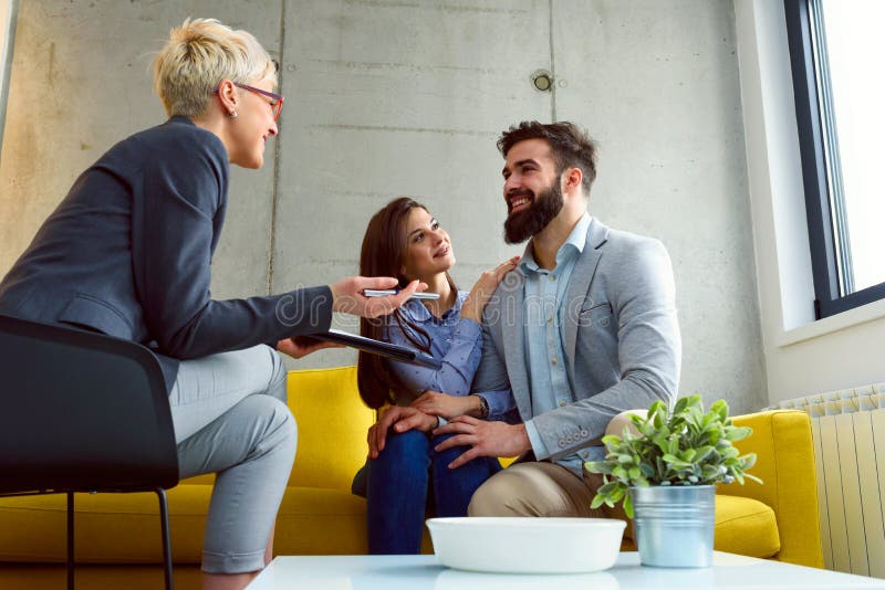 Les jeunes ménage à leur conseiller financier photographie stock libre de droits Les jeunes ménage à leur conseiller financier photographie stock libre de droits