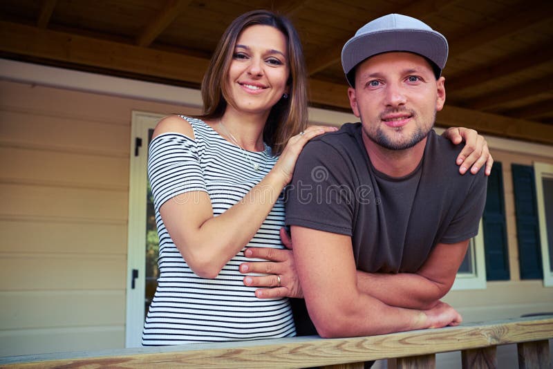 Les jeunes ont marié des couples posant à l'appareil-photo tout en se tenant sur image stock Les jeunes ont marié des couples posant à l'appareil-photo tout en se tenant sur image stock