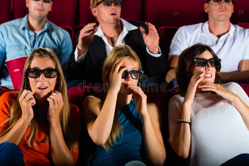 Young people strained watching 3d movie at movie theater. Young people strained watching 3d movie at movie theater