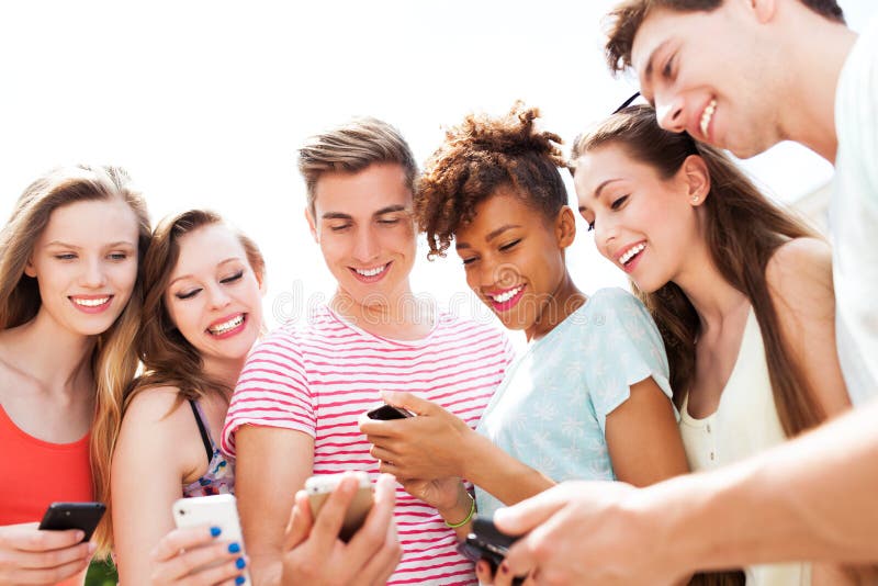 Les jeunes regardant des smartphones photo stock Les jeunes regardant des smartphones photo stock