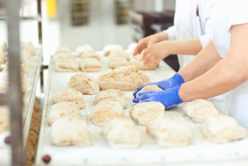 Les mains de Baker préparent la pâte pour faire cuire du pain