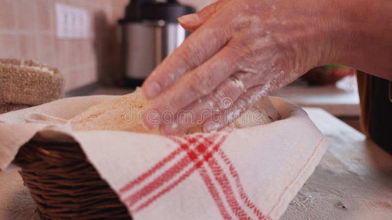 Les mains de femme ont mis la pâte à pain à faire lever le panier banque de vidéos
