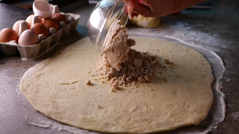 Les mains de femme ont écarté remplir sur la pâte étirée pour un gâteau de petit pain de noix clips vidéos