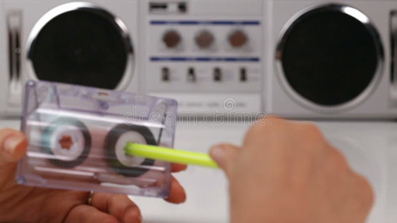Les mains de femme rebobinent une cassette sonore utilisant un stylo banque de vidéos