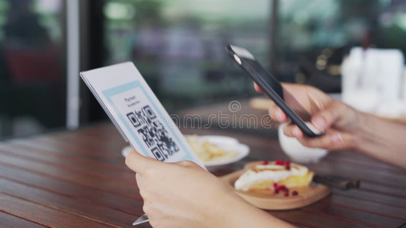 Les mains de femmes utilisent le téléphone pour scanner le code qr pour choisir le menu de nourriture. Balayage pour obtenir des r banque de vidéos