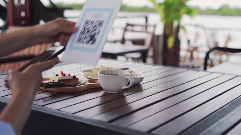 Les mains de femmes utilisent le téléphone pour scanner le code qr pour choisir le menu de nourriture. Balayage pour obtenir des r clips vidéos