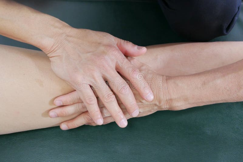 Les mains de physiothérapeute traitent le genou au patient images libres de droits Les mains de physiothérapeute traitent le genou au patient images libres de droits