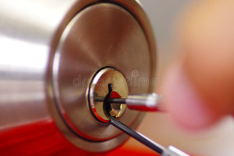 Les mains de plan rapproché du serrurier employant le métal sélectionnent des outils pour ouvrir la porte verrouillée image stock Les mains de plan rapproché du serrurier employant le métal sélectionnent des outils pour ouvrir la porte verrouillée image stock