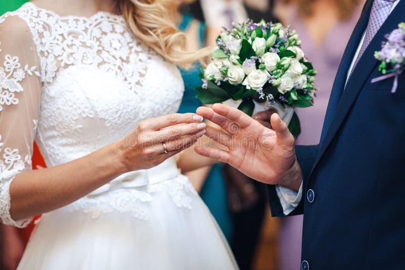 Les mains des nouveaux mariés Une main du ` s des femmes met dessus un anneau La jeune mariée remet le plan rapproché photos libres de droits Les mains des nouveaux mariés Une main du ` s des femmes met dessus un anneau La jeune mariée remet le plan rapproché photos libres de droits