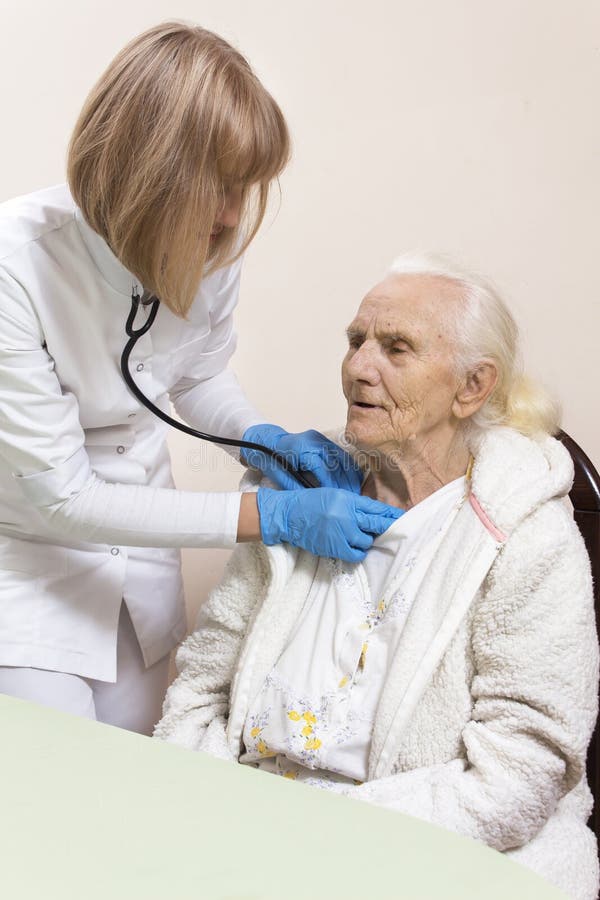 Les mains du docteur d'interniste examinent les poumons de dame âgée même avec un stéthoscope photo stock