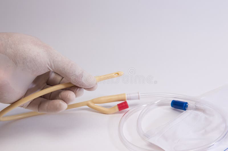 Les mains du docteur dans les gants m?dicaux tiennent un cath?ter m?dical, une gouttelette et l'urinoir photographie stock libre de droits Les mains du docteur dans les gants m?dicaux tiennent un cath?ter m?dical, une gouttelette et l'urinoir photographie stock libre de droits
