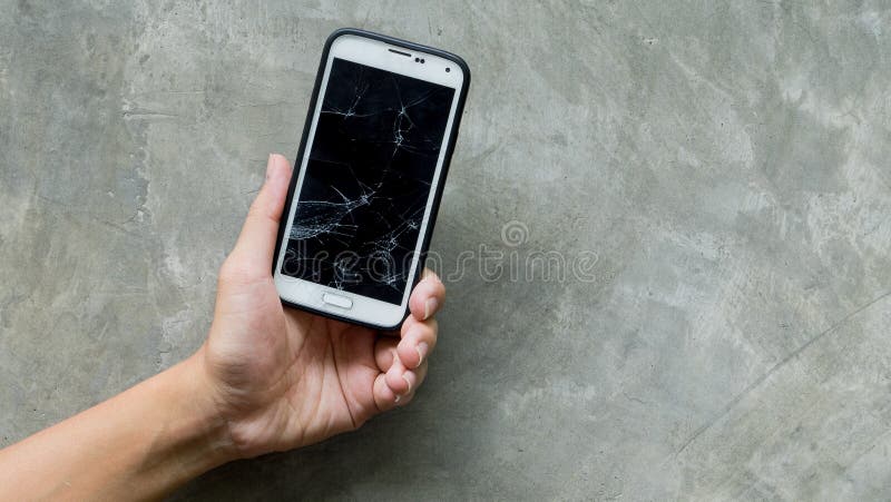 Les mains tenant le Smart-téléphone cassé de moblie se sont concentrées sur le mur en béton image libre de droits Les mains tenant le Smart-téléphone cassé de moblie se sont concentrées sur le mur en béton image libre de droits