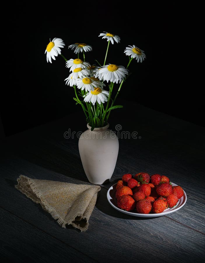 Les marguerites alba, cette camomille blanche dispose à dormir, à côté d'une serviette et d'un plat des fraises fraîches photographie stock libre de droits Les marguerites alba, cette camomille blanche dispose à dormir, à côté d'une serviette et d'un plat des fraises fraîches photographie stock libre de droits