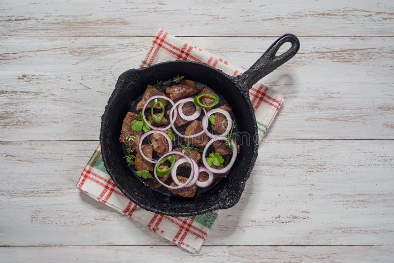 Les morceaux de boeuf ont cuit sur une vieille casserole de fonte photos stock Les morceaux de boeuf ont cuit sur une vieille casserole de fonte photos stock