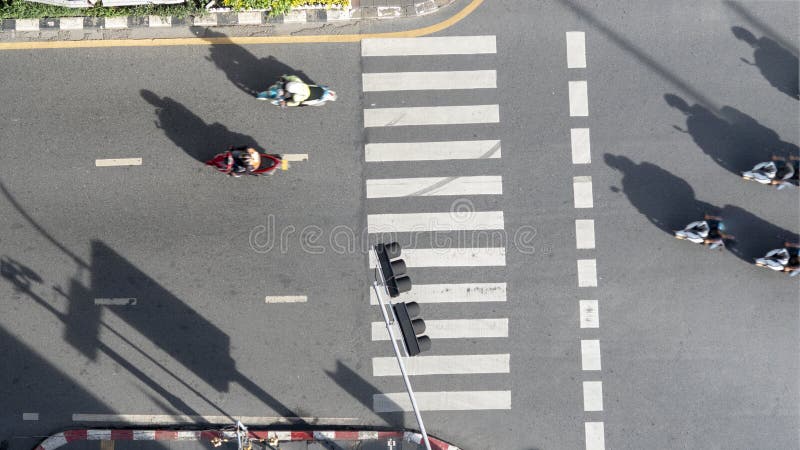 motorcycles pass across pedestrian crosswalk road in city top aerial view. motorcycles pass across pedestrian crosswalk road in city top aerial view.