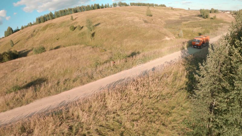 Les mouches au-dessus de la vallée le long de la route près de terre conduire le camion de pointe et tombe dans l'herbe anéantie d clips vidéos