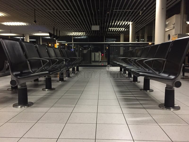 Les nombreuses chaises à un couloir vide à l'aéroport la nuit. De nombreux transats à un hall vide à l'aéroport la nuit