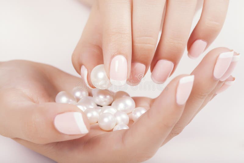 Les ongles de la belle femme avec la manucure française photographie stock libre de droits Les ongles de la belle femme avec la manucure française photographie stock libre de droits
