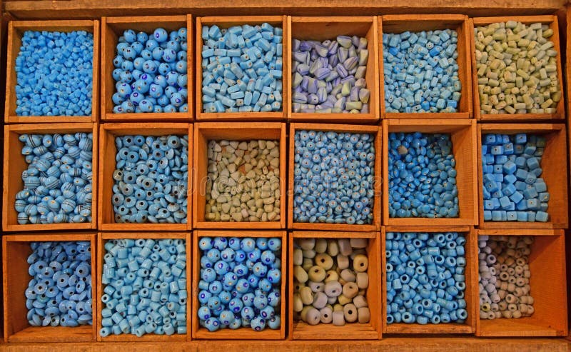 Colourful beads mainly blue in various tones in different sizes and shapes sold in wooden compartment in a flea market shop in Paris France. Colourful beads mainly blue in various tones in different sizes and shapes sold in wooden compartment in a flea market shop in Paris France.