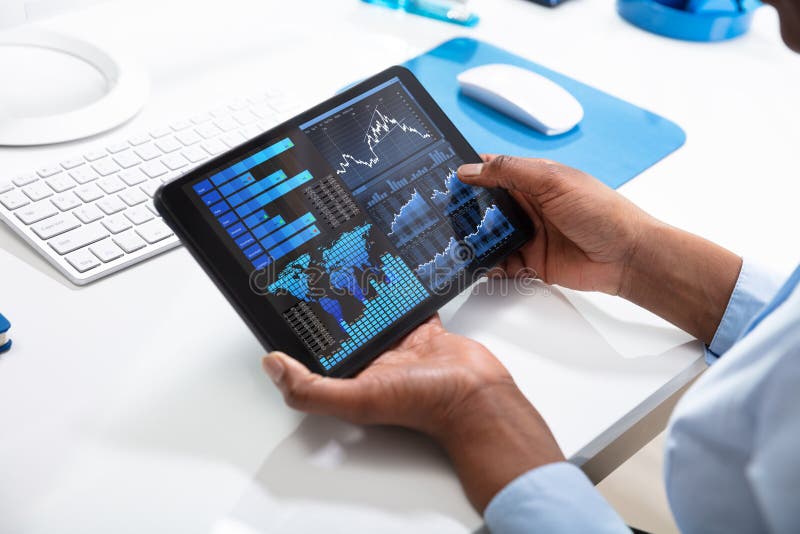 Businessperson`s Hand Pointing On Tablet Screen Showing Graph Over The Desk. Businessperson`s Hand Pointing On Tablet Screen Showing Graph Over The Desk