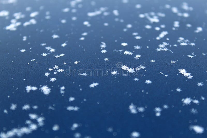 Les petits beaux flocons de neige se trouvent sur une surface douce photographie stock Les petits beaux flocons de neige se trouvent sur une surface douce photographie stock
