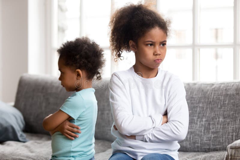 Les petits enfants de mêmes parents têtus évitent de parler après combat photo stock Les petits enfants de mêmes parents têtus évitent de parler après combat photo stock
